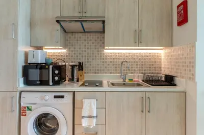 a kitchen with a washing machine and a sink at Sea-View Studio at Seven Palm in Dubai