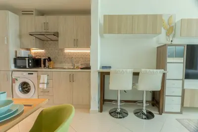 a kitchen with a counter and two stools at Sea-View Studio at Seven Palm in Dubai