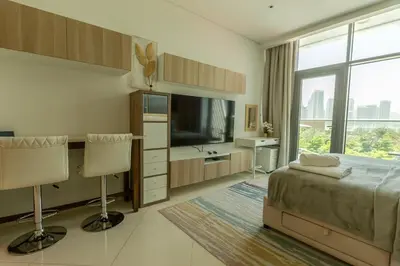 a bedroom with a bed and a desk and a television at Sea-View Studio at Seven Palm in Dubai