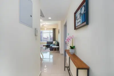 a hallway with a table and a living room at White Sage High Floor 1BR Metro Access JLT in Dubai