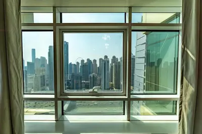 an open window with a view of a city skyline at White Sage High Floor 1BR Metro Access JLT in Dubai