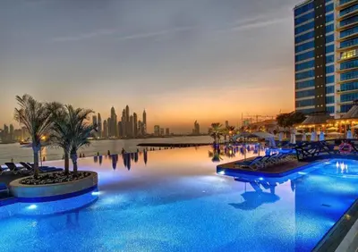 a large swimming pool with a city skyline in the background at Tiara Residence, The Palm - Elegant 1BR with Full Sea View in Dubai