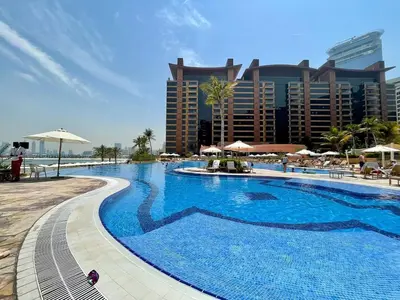 a large swimming pool in front of a hotel at Tiara Residence, The Palm - Elegant 1BR with Full Sea View in Dubai