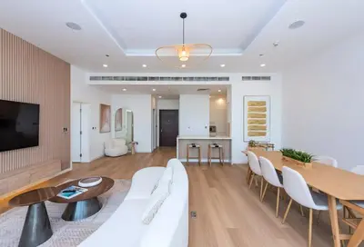 a living room with a white couch and a table at Tiara Residence, The Palm - Elegant 1BR with Full Sea View in Dubai