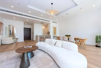 a living room with a white couch and a table at Tiara Residence, The Palm - Elegant 1BR with Full Sea View in Dubai