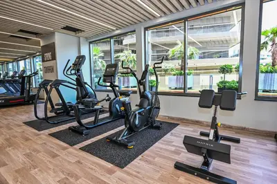 a gym with treadmills and elliptical machines at Cozy & Spacious 2 BHK Downtown in Dubai