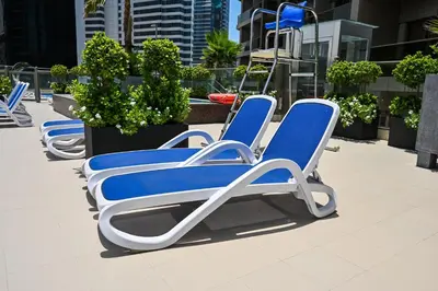 a row of blue and white chairs on a rooftop at Cozy & Spacious 2 BHK Downtown in Dubai