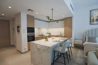 a kitchen and living room with a island in a room at Stylish Studio at Berkeley Place by Ellington in Dubai