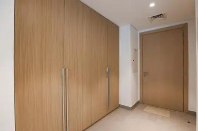 a room with wooden cabinets and a door at Stylish Studio at Berkeley Place by Ellington in Dubai