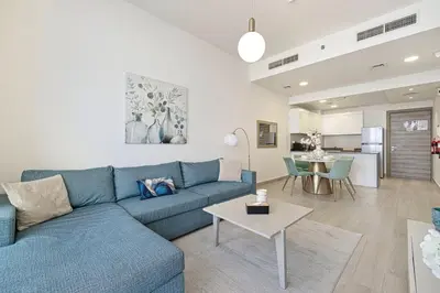 a living room with a blue couch and a table at Luxury One-Bedroom Apartment in Bloom Heights in Dubai
