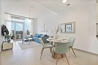 a living room with a table and a blue couch at Luxury One-Bedroom Apartment in Bloom Heights in Dubai