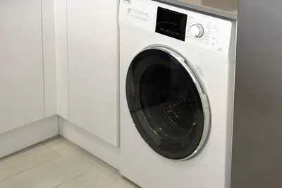a white washing machine in a white laundry room at Luxury One-Bedroom Apartment in Bloom Heights in Dubai