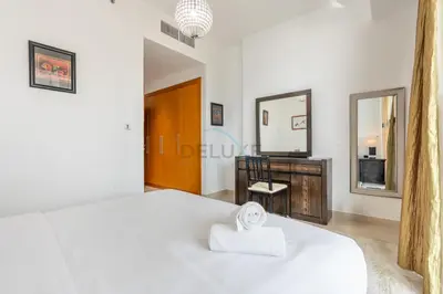 a bedroom with a white bed and a mirror at Few Metres from Marina Beach, Arabian Gulf Views - Trident Grand Residences, Dubai Marina by Deluxe Holiday Homes in Dubai