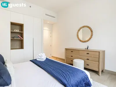 a bedroom with a bed and a dresser and a mirror at HiGuests - Breezy 1 BR Retreat Near La Mer Beach in Dubai