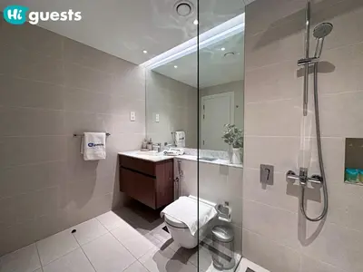 a bathroom with a shower and a toilet and a sink at HiGuests - Breezy 1 BR Retreat Near La Mer Beach in Dubai