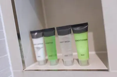 a row of four beauty products in a shelf at Goldbest Beachfront 2BR La Mer in Dubai