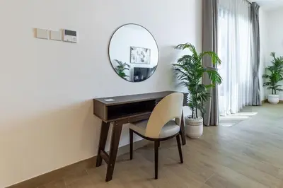 a desk with a chair and a mirror in a room at Goldbest Beachfront 2BR La Mer in Dubai