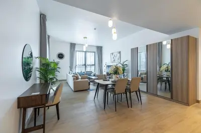 a living room with a table and chairs at Goldbest Beachfront 2BR La Mer in Dubai