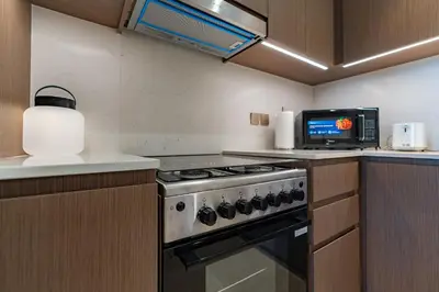 a kitchen with a stove and a microwave at Full Burj Khalifa and Fountain View from All Rooms in Dubai