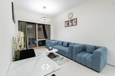 a living room with a blue couch and a table at Full Burj Khalifa and Fountain View from All Rooms in Dubai