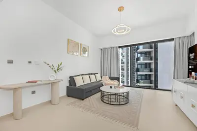 a white living room with a couch and a table at Majestic Act2 1BR Dowtown Dubai in Dubai