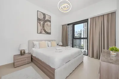 a white bedroom with a large bed and a window at Majestic Act2 1BR Dowtown Dubai in Dubai