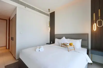 a bedroom with a white bed with a table on it at Livbnb Beachfront 2BR in Address JBR Sea & Ain Dubai Views in Dubai