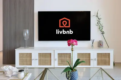 a living room with a tv on top of a white cabinet at Livbnb Beachfront 2BR in Address JBR Sea & Ain Dubai Views in Dubai