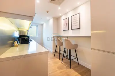 a kitchen with a bar and stools in a room at High-Floor 2BR with Pool and City Views, Near Tram Station and Dubai Marina Walk, Marina Heights, Dubai Marina by Deluxe Holiday Homes in Dubai