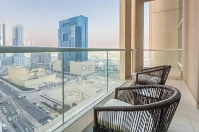 two chairs on a balcony with a view of a city at High-Floor 2BR with Pool and City Views, Near Tram Station and Dubai Marina Walk, Marina Heights, Dubai Marina by Deluxe Holiday Homes in Dubai
