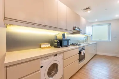 a kitchen with a washing machine and a washer at High-Floor 2BR with Pool and City Views, Near Tram Station and Dubai Marina Walk, Marina Heights, Dubai Marina by Deluxe Holiday Homes in Dubai