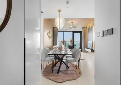 a dining room with a table and white chairs at Novity Signature Homes in Dubai