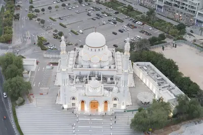 a large white building with stairs in a parking lot at Trendy & Cozy Getaway in Dubai
