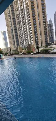 a large swimming pool in front of tall buildings at Trendy & Cozy Getaway in Dubai