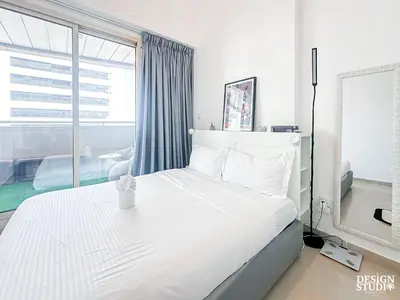 a bedroom with a white bed and a large window at DREAM by Design Studio in Dubai