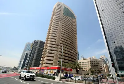 a car driving down a city street with tall buildings at DREAM by Design Studio in Dubai