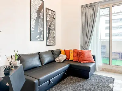 a black leather couch in a living room with a window at DREAM by Design Studio in Dubai