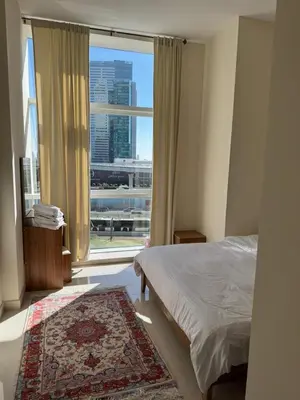 a bedroom with a bed and a large window at Affordable master bedroom hotel apartment in Dubai