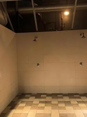 an empty gymnasium with white tiled walls at Affordable master bedroom hotel apartment in Dubai
