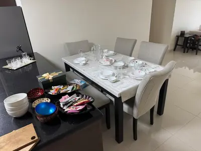a dining room table with chairs and a table with glasses on it at Stylish 2BHK in Prime Location in Dubai