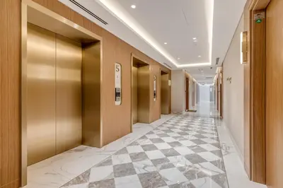 a hallway in a building with a checkerboard floor at GLOBALSTAY Azizi Riviera 59 in Dubai