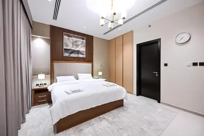 a bedroom with a large bed and a clock on the wall at Luxury 3BR Full Burj Khalifa View Stay by World's Tallest Tower in Dubai