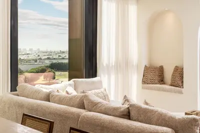 a living room with a couch and a large window at Seraya at Residence 110 in Dubai