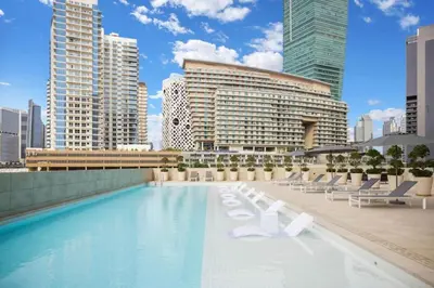 a pool with lounge chairs and a building with tall buildings at Seraya at Residence 110 in Dubai