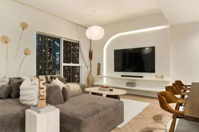 a living room with a couch and a tv at Seraya Residences at Urban Oasis by Missoni in Dubai