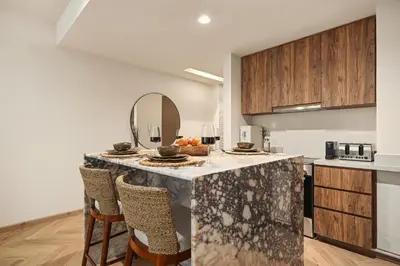 a kitchen with a table with a bowl of fruit on it at Seraya Residences at Urban Oasis by Missoni in Dubai