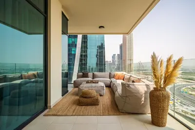 a living room with a couch and a large window at Seraya Residences at Urban Oasis by Missoni in Dubai