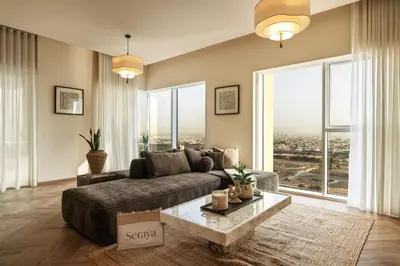a living room with a couch and large windows at Seraya Residences at Urban Oasis by Missoni in Dubai
