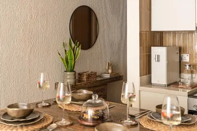 a table with glasses and plates and a mirror at Seraya Residences at Urban Oasis by Missoni in Dubai