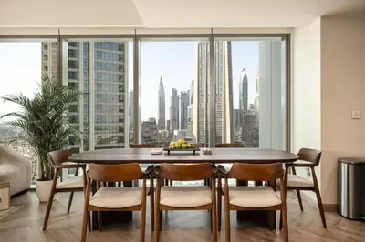 a dining room with a table and chairs and a large window at Seraya Residence 7 - 4BDR - Burj and DIFC skyline Views in Dubai